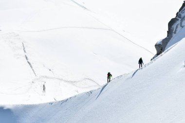 Beyaz Vadi 'de karlı bir yamaçta yürüyüş yapan gezginler Aiguille du Midi 3842 metre, Chamonix, Fransa