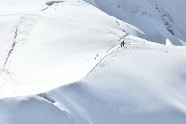 Beyaz Vadi 'de karlı bir yamaçta yürüyüş yapan gezginler Aiguille du Midi 3842 metre, Chamonix, Fransa