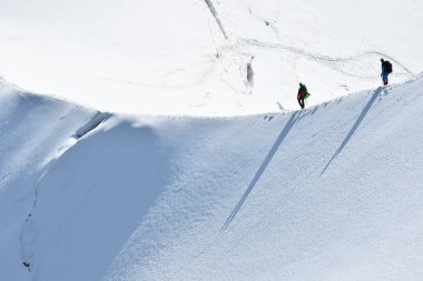 Beyaz Vadi 'de karlı bir yamaçta yürüyüş yapan gezginler Aiguille du Midi 3842 metre, Chamonix, Fransa