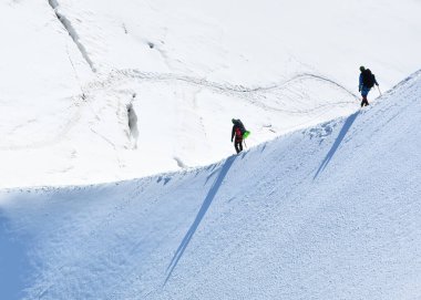 Beyaz Vadi 'de karlı bir yamaçta yürüyüş yapan gezginler Aiguille du Midi 3842 metre, Chamonix, Fransa