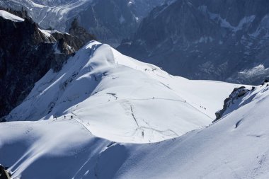 Beyaz Vadi 'de karlı bir yamaçta yürüyüş yapan gezginler Aiguille du Midi 3842 metre, Chamonix, Fransa