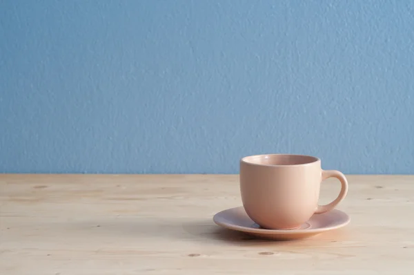 Escritorio de oficina taza de café en piso de madera y fondo de cemento azul — Foto de Stock