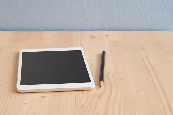 Schreibtisch mit Tablet und Bleistift auf Holzböden. — Stockfoto