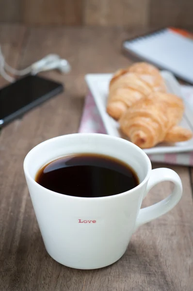 Mesa de comedor con taza de café caliente y croissant — Foto de Stock