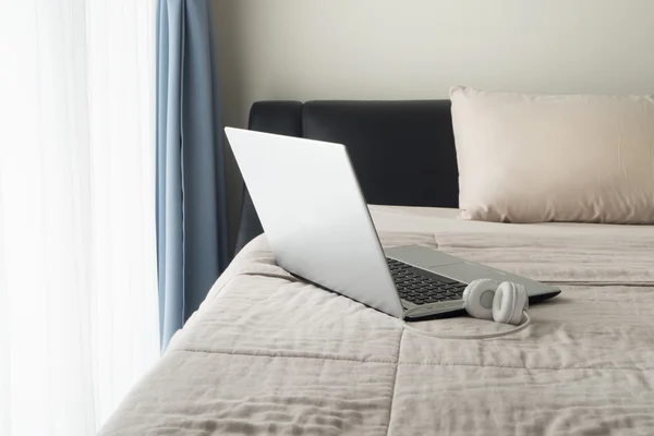 The bed with Morning Coffee,earphone and laptop