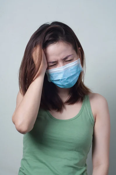 Retrato de mujer asiática en una camiseta verde con una máscara de hea — Foto de Stock