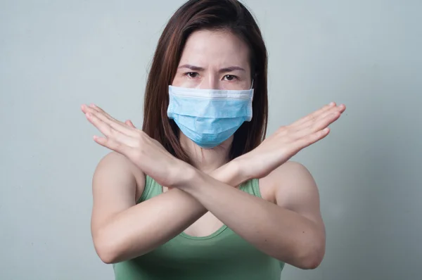Retrato de mujer asiática en una camiseta verde con una demostración de la máscara — Foto de Stock