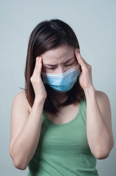 Retrato de desgaste de las mujeres asiáticas una máscara son dolor de cabeza sensación. — Foto de Stock