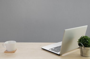 Ofis masaları ile defter, yeşil ağaç sepet ve beyaz kahve üzerinde