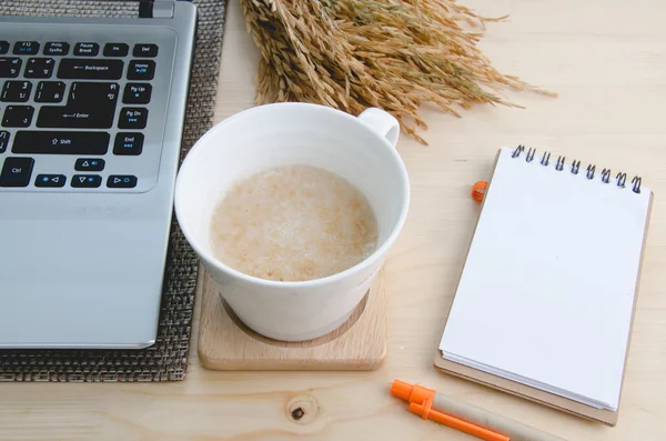 Drink a glass of white cereal. Placed on the desk beside the Not — Stock Photo, Image