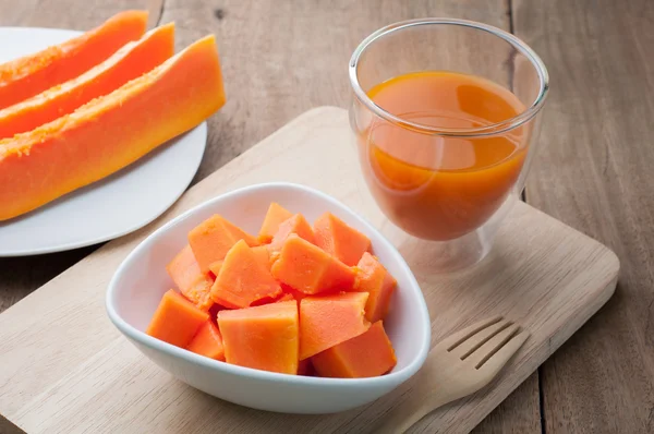 Grupo de mamão laranja no prato branco, suco de mamão e ba de madeira — Fotografia de Stock