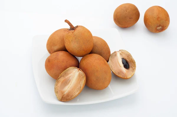 Gruppo di Sapodilla su piatto e fondo bianco, frutta thailandese . — Foto Stock