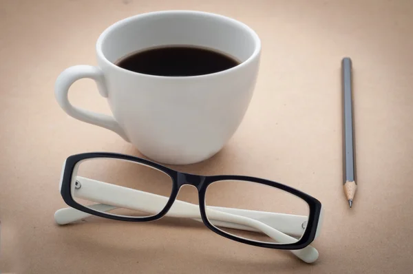 Escritorio de oficina con vasos blancos y negros, taza de café . — Foto de Stock