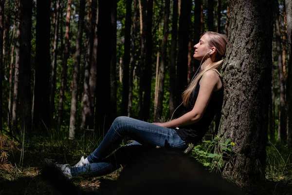 Девушка Лесу Сидит Прислонившись Дереву Наушниками Слушающими Музыку Отдых Природе — стоковое фото