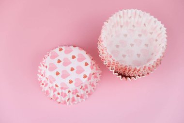 Pembe arka planda kalpleri olan boş pembe kek kalıbı. Sevgililer Günü