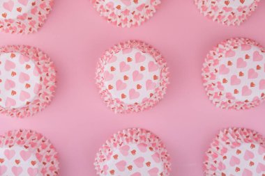 Pembe arka planda kalpleri olan boş pembe kek kalıbı. Sevgililer Günü