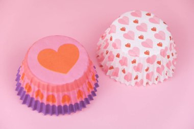 Pembe arka planda kalpleri olan boş pembe kek kalıbı. Sevgililer Günü