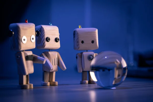 Küçük tahta oyuncak bir robot karanlıkta camdan bir topa bakıyor. Duvar kağıdı, mavi arka plan. loş ışık