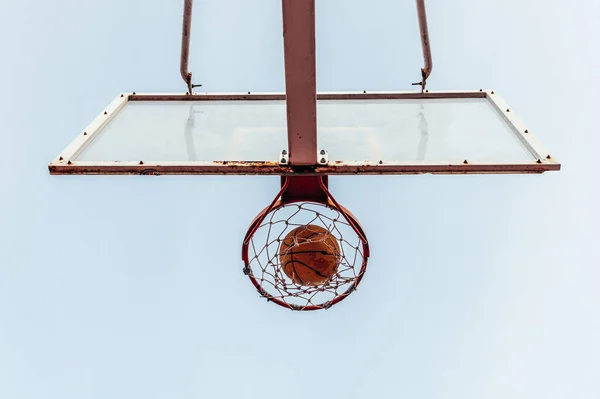 Bottom view of a basketball basket. Ball entering through the hoop.