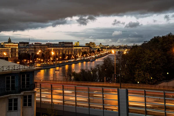 川や夕日を背景にした近代的な建物や高速道路のある街 — ストック写真