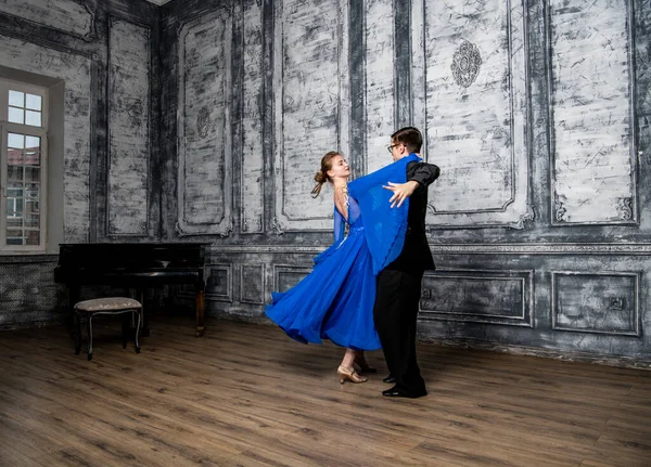 Молодой Человек Танцует Девушкой Синем Бальном Платье Сером Танцевальном Зале — стоковое фото