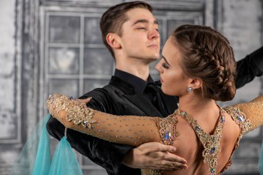 Dans kostümlü genç çift balo salonunda tango yapıyor.