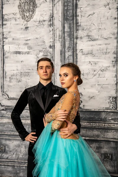 young couple in evening dance costumes posing in the dance hall
