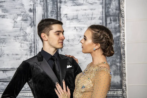 young couple in evening dance costumes posing in the dance hall