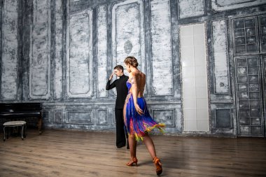 Dans kostümlü güzel bir çift koridorda Latin dansı yapıyor.