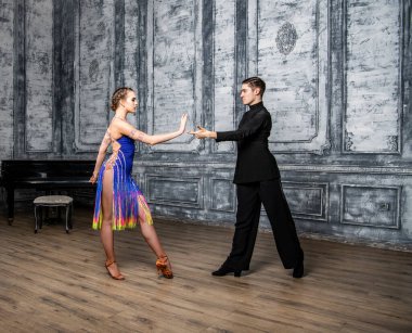 Dans kostümlü güzel bir çift koridorda Latin dansı yapıyor.