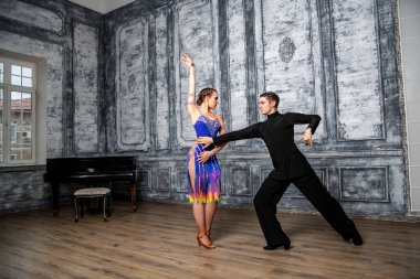 Dans kostümlü güzel bir çift koridorda Latin dansı yapıyor.