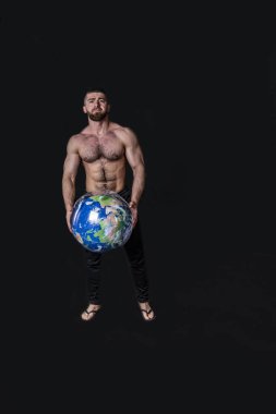 Yakışıklı, fiziksel olarak iyi gelişmiş ve elinde sahte bir gezegen olan bir adam.