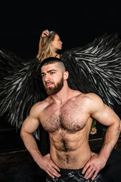 angel with black wings and man on a black background