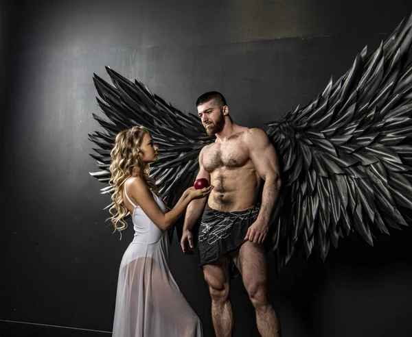 angel with black wings and a representative of the human race on a black background