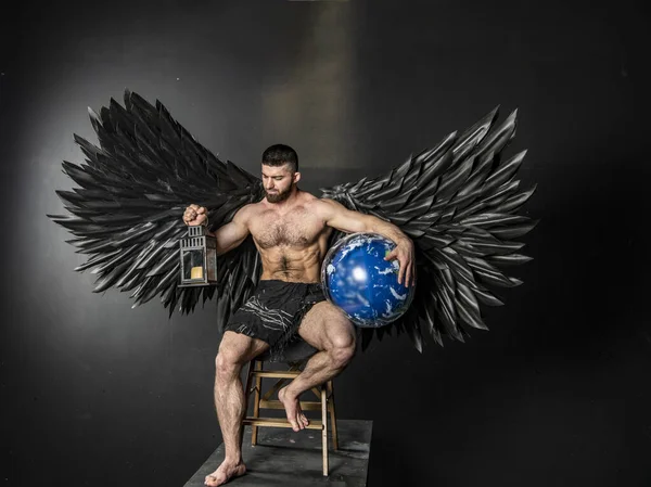 Schöner Muskulöser Mann Engelskostüm Mit Schwarzen Flügeln Auf Schwarzem Hintergrund — Stockfoto
