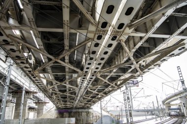 Otoyollu şehir manzarası gri gökyüzüne karşı köprüleri ve gökdelenleri takip ediyor