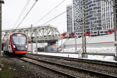 Otoyollu şehir manzarası gri gökyüzüne karşı köprüleri ve gökdelenleri takip ediyor