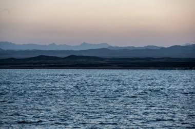 Deniz fenerinin yanındaki mercan resifinde gün batımı.