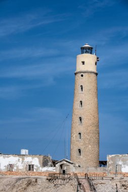 Deniz fenerinin yanındaki mercan resifinde gün batımı.