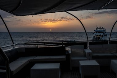 Deniz fenerinin yanındaki mercan resifinde gün batımı.