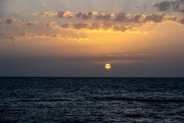 Deniz fenerinin yanındaki mercan resifinde gün batımı.