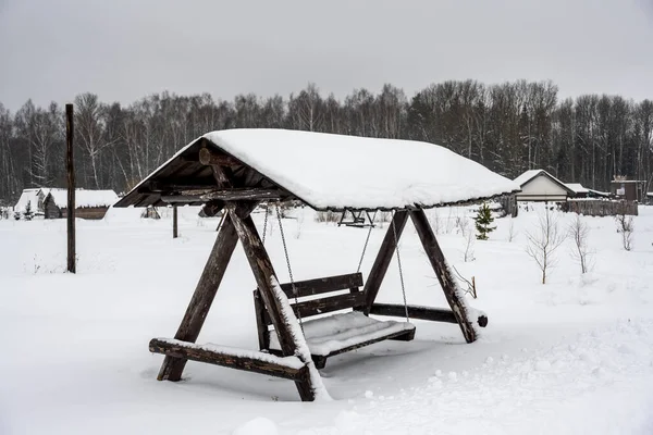 Bänk Med Solskydd Står Ett Snötäckt Fält — Stockfoto