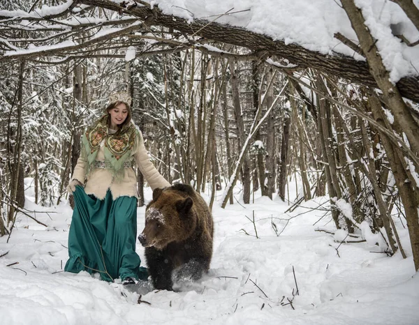 民族衣装のロシアの美しさは 茶色のクマと冬の森の中で雪滴を収集します — ストック写真