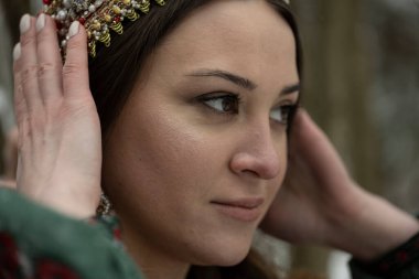  Ulusal kostümlü güzel bir Rus kızı ve kış ormanında kahverengi bir ayı. 