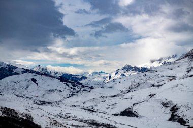Osetya dağlarında karla kaplı ağaçlarla ve dağlarla kaplı bir manzara.