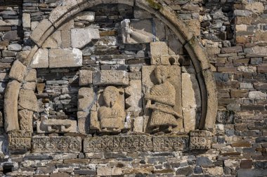 Kışın, kar ve mavi gökyüzünün arka planında bir dağ yamacında taş kaleler ve antik kalıntılar. 
