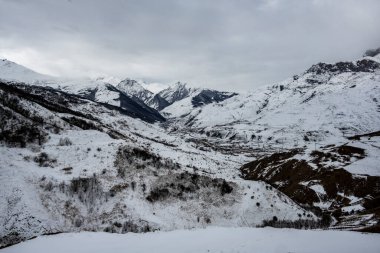 Bir kar yağışı sonrası kışın dağların arasındaki vadide antik bir taş manastırı. 