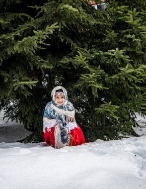 Güzel bir kız kış parkında karda oynayıp poz veriyor. 