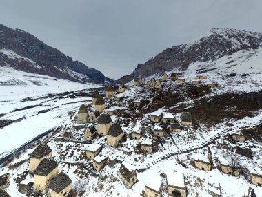 Ingushetia 'nın karla kaplı dağlarındaki antik bir kalenin insansız hava aracının panoramik görüntüsü. 