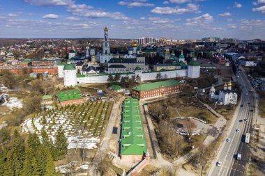 Sergiev Posad 'daki Trinity-Sergius Lavra' nın altın kulelerinin panoramik görüntüsü ve antik mimari çözümleri. Güneşli bir bahar gününde insansız hava aracından çekildi. 